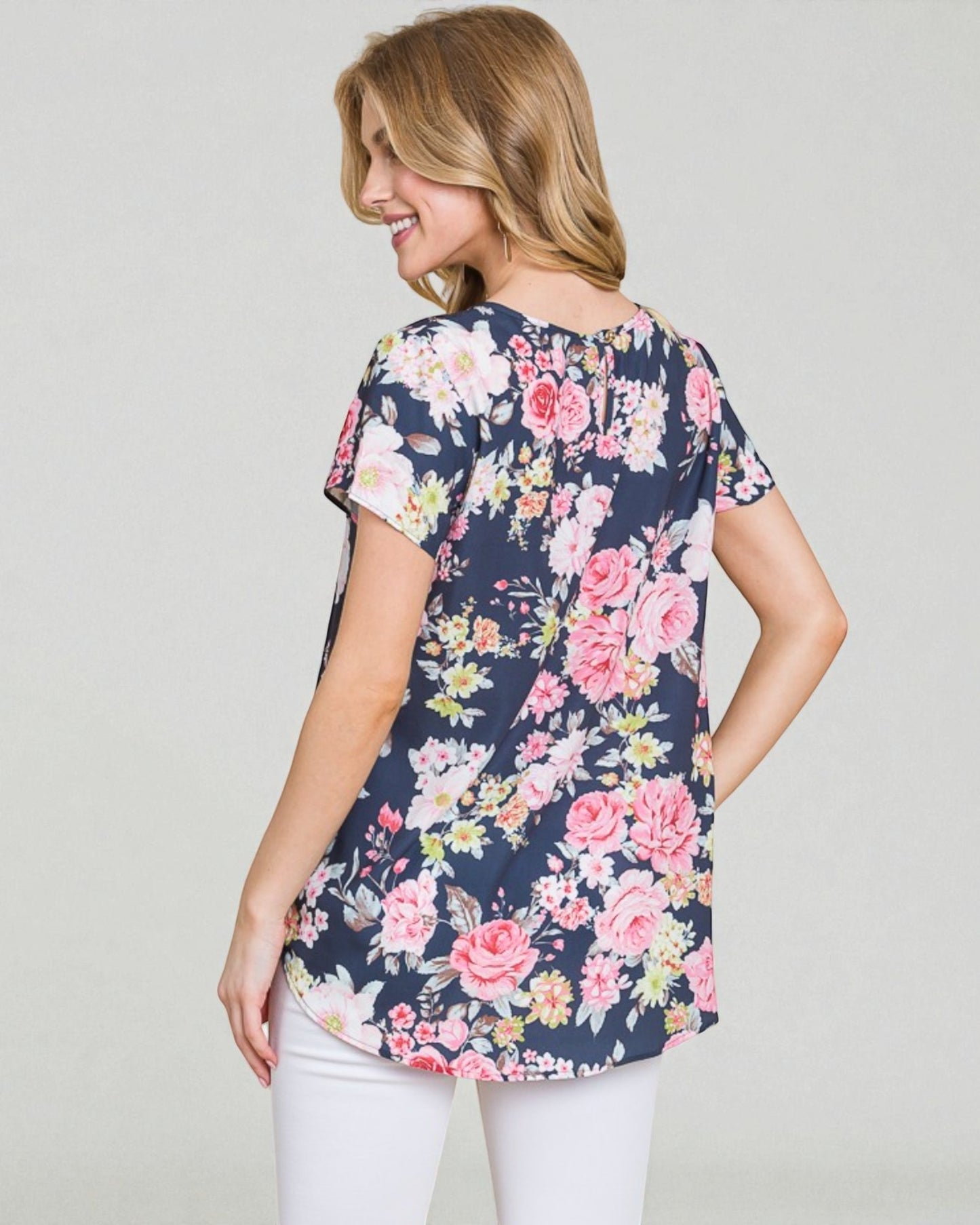 Woman wearing a navy floral blouse against a plain background