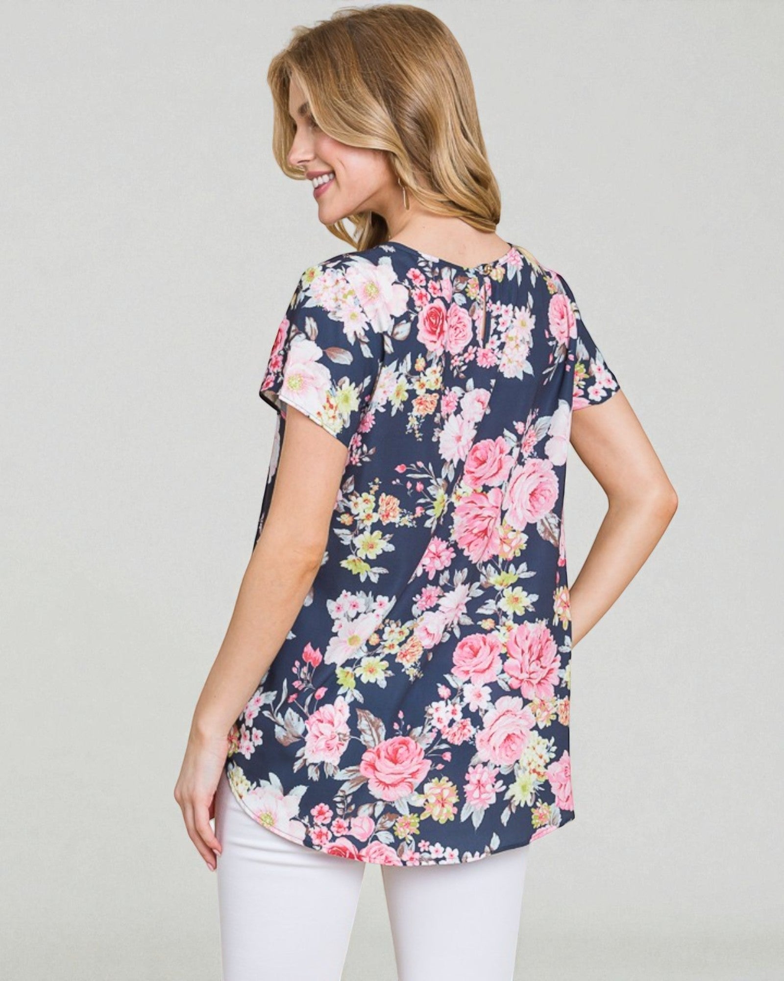 Woman wearing a navy floral blouse against a plain background