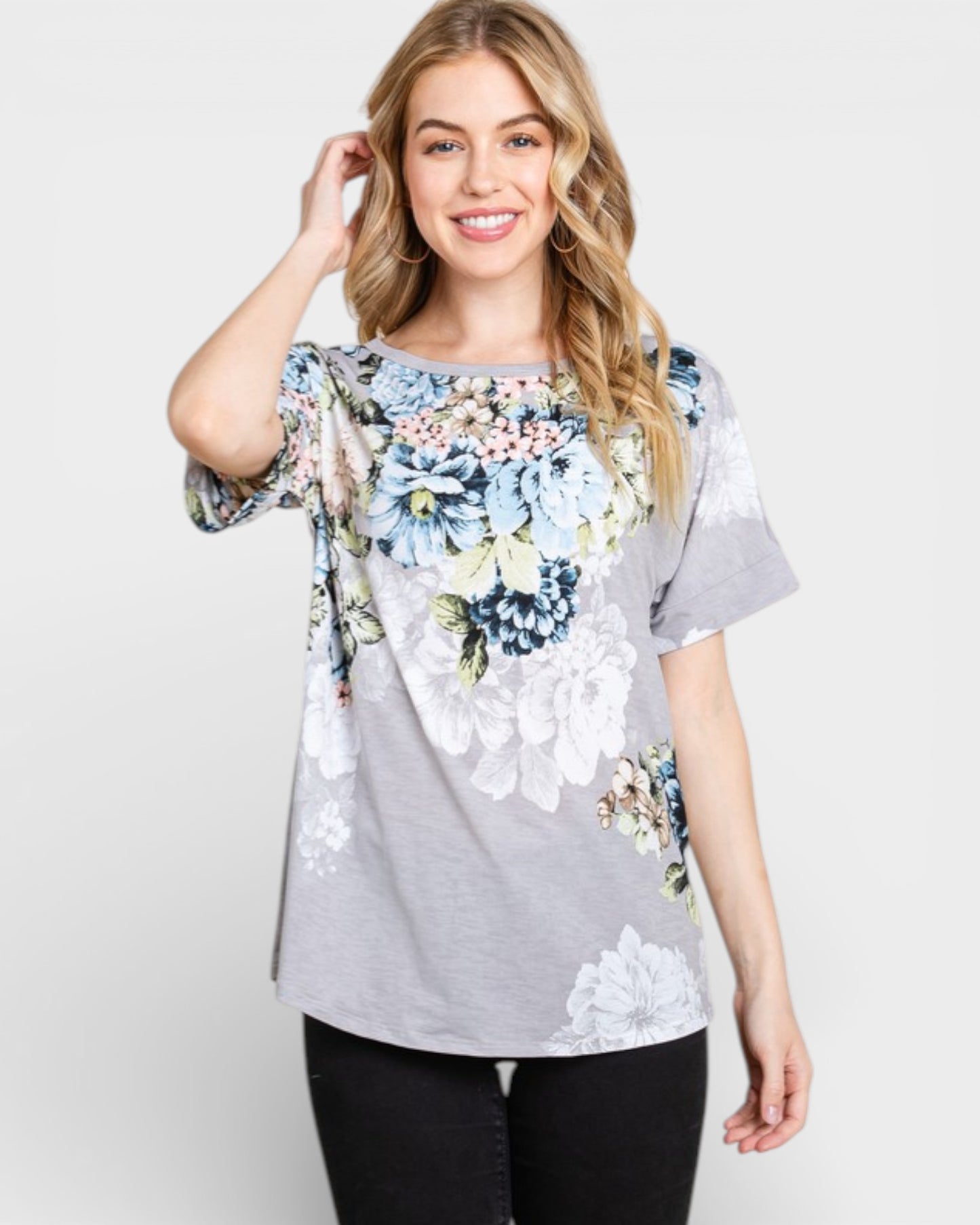 Woman wearing a gray floral blouse against a white background