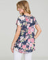 Woman wearing a navy floral blouse against a plain background