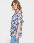 Woman wearing a floral patterned top on a white background