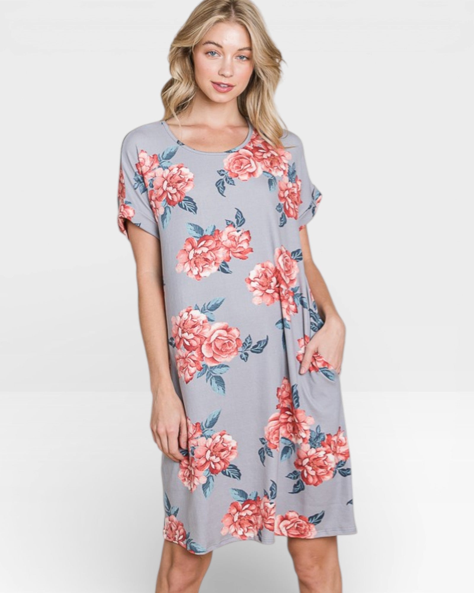 Woman wearing a gray dress with pink floral patterns on a white background