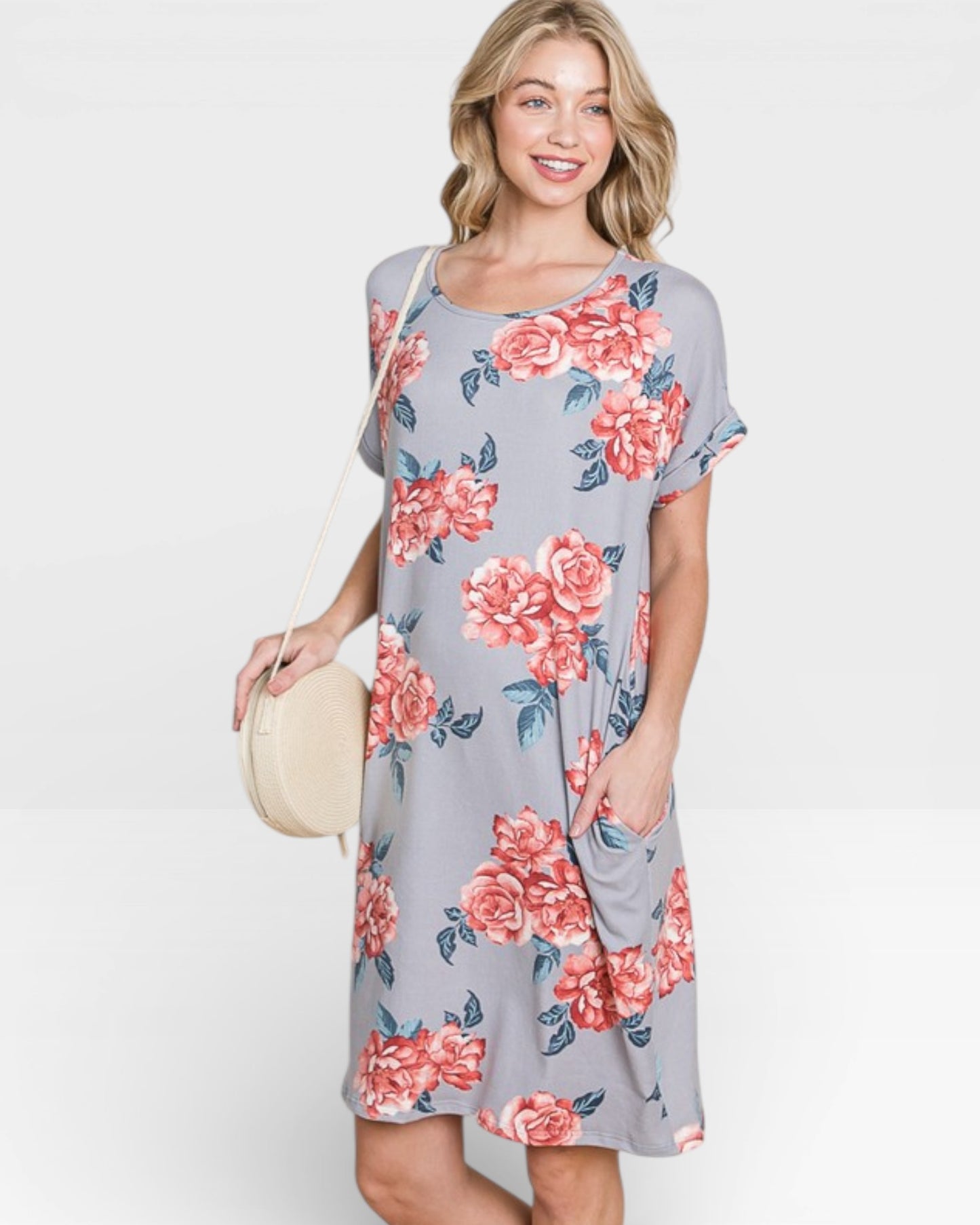 Woman wearing a gray dress with pink floral pattern on a white background