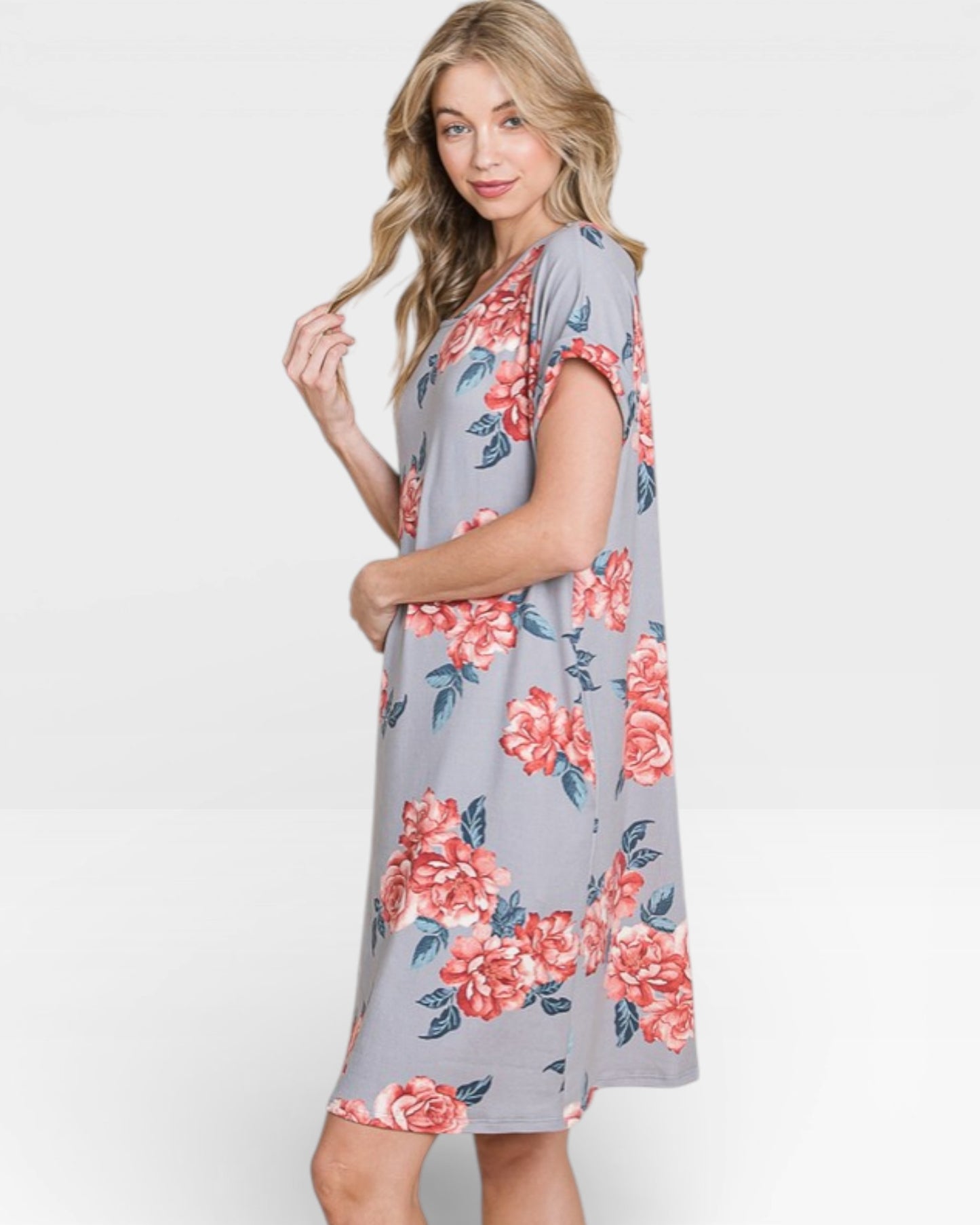 Woman wearing a gray dress with pink floral pattern on a white background