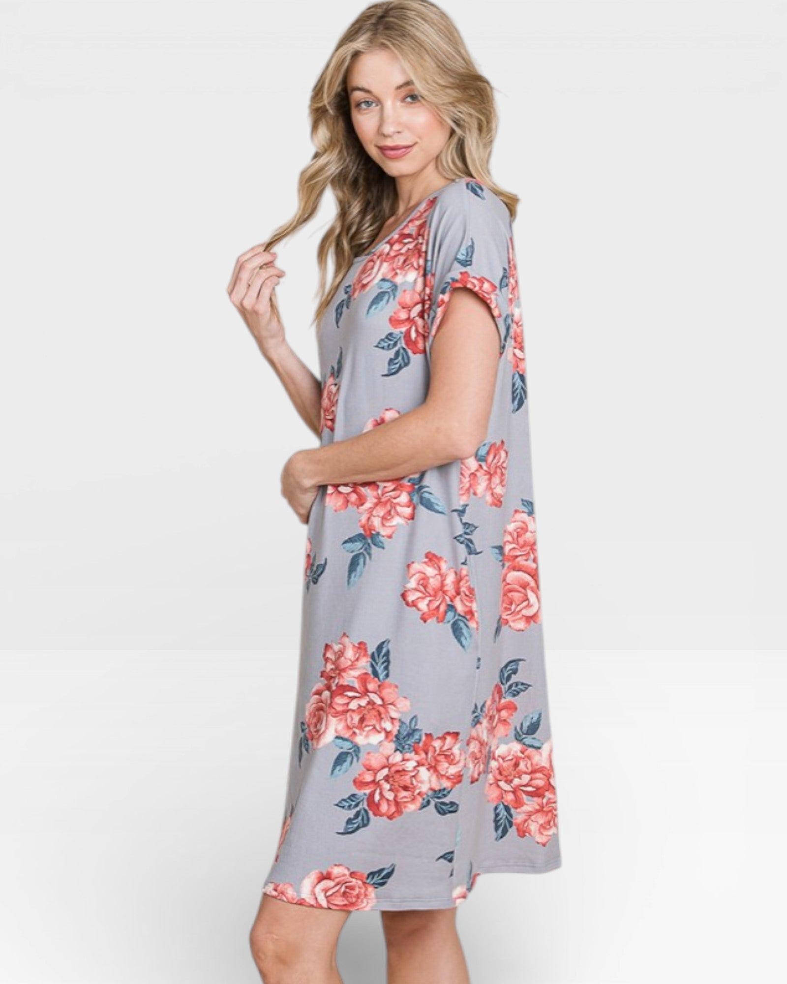 Woman wearing a gray dress with pink floral pattern on a white background