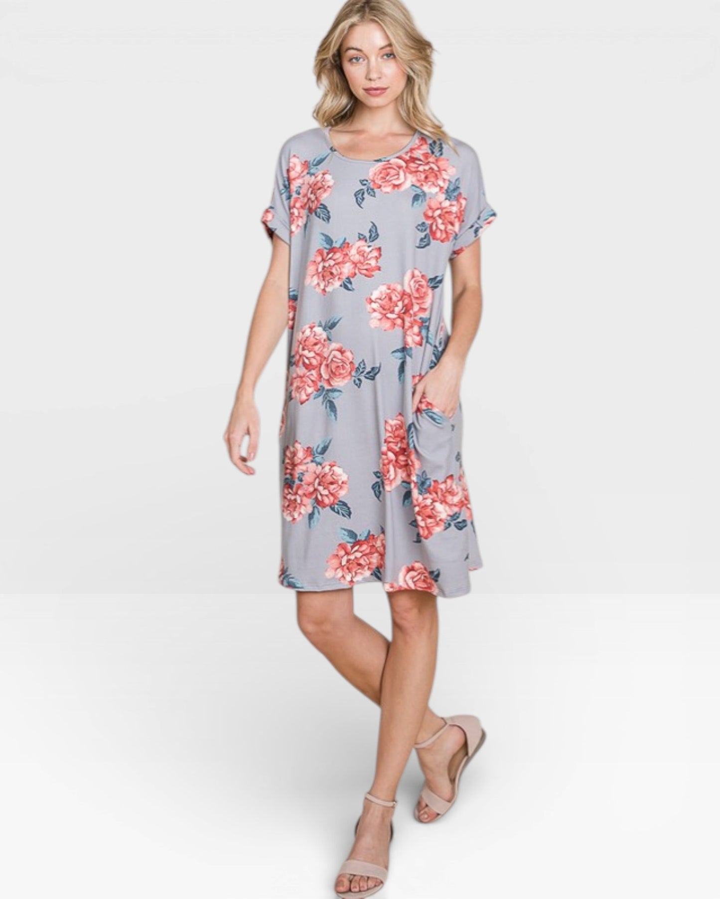 Woman wearing a gray dress with pink floral pattern on a white background