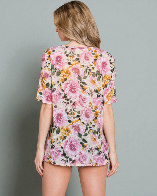 Woman wearing a floral pajama set against a gray background