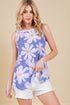 Woman wearing a blue tank top with white floral patterns on a beige background