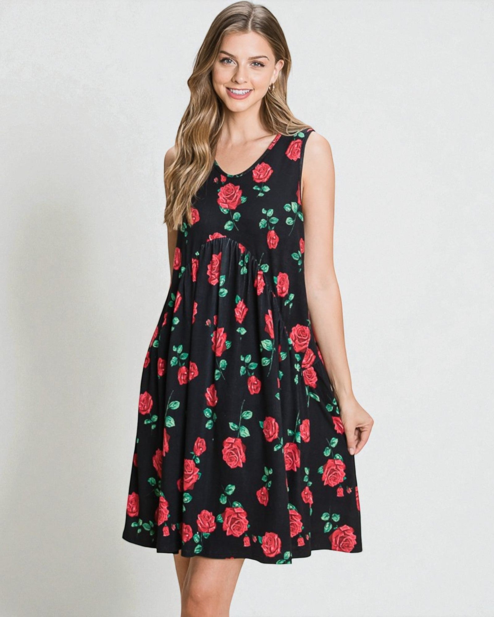 Woman wearing a black sleeveless dress with red rose pattern on a plain background