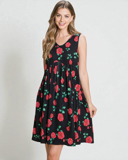 Woman wearing a black sleeveless dress with red rose pattern on a plain background