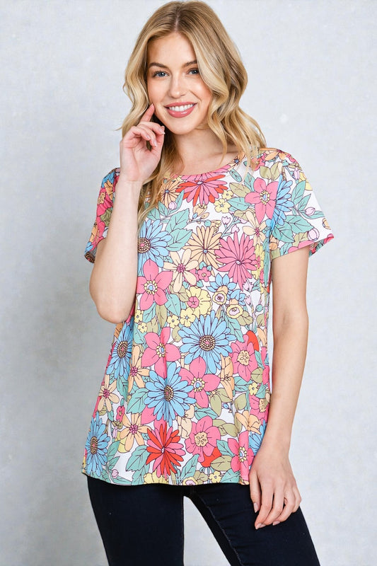 Woman wearing a colorful floral t-shirt against a plain background