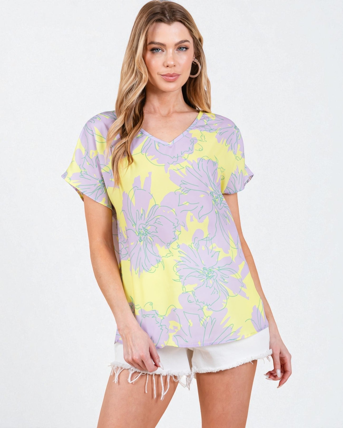 Woman wearing a purple and yellow floral oversized t-shirt on a white background