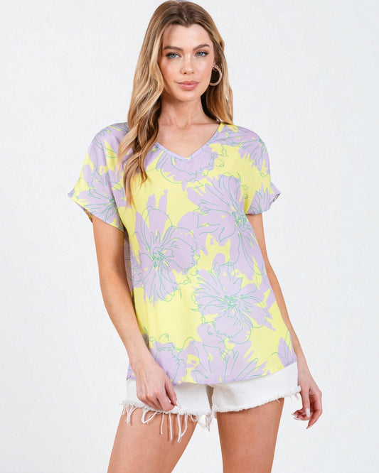 Woman wearing a purple and yellow floral oversized t-shirt on a white background