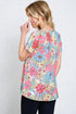 Woman wearing a colorful floral blouse against a white background