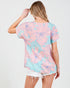 Woman wearing a pastel floral patterned top on a white background