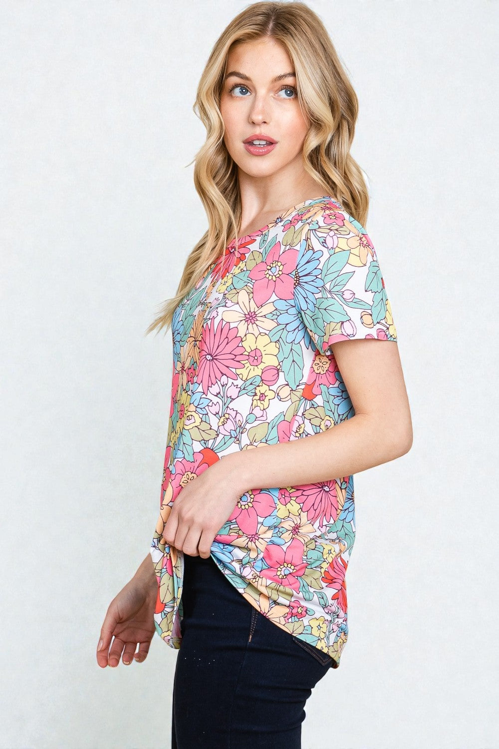 Woman wearing a colorful floral blouse against a white background