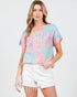 Woman wearing a light blue floral blouse with pink flowers on a white background