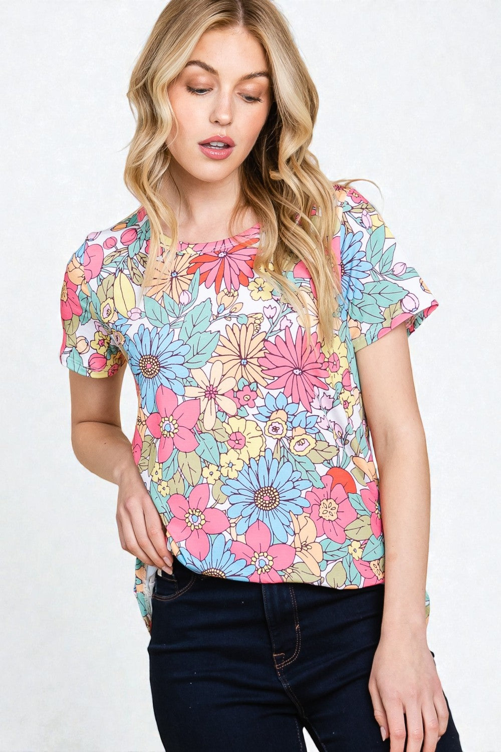Woman wearing a colorful floral top on a white background