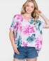 Woman wearing a floral oversized shirt and denim shorts on a white background