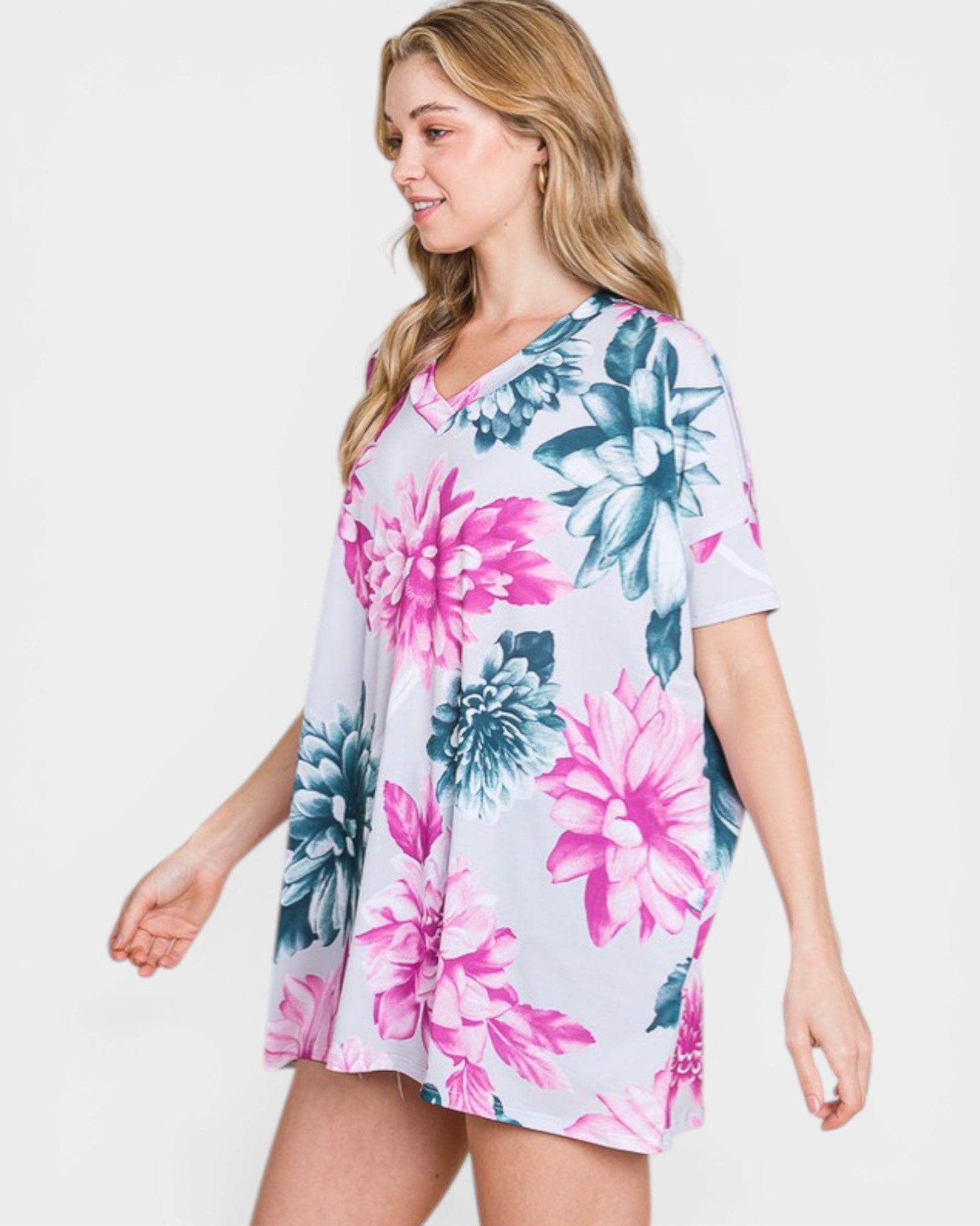 Woman wearing a floral dress with pink and blue flowers on a white background