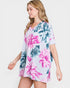Woman wearing a floral dress with pink and blue flowers on a white background