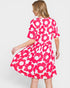 Woman wearing a pink floral dress on a white background