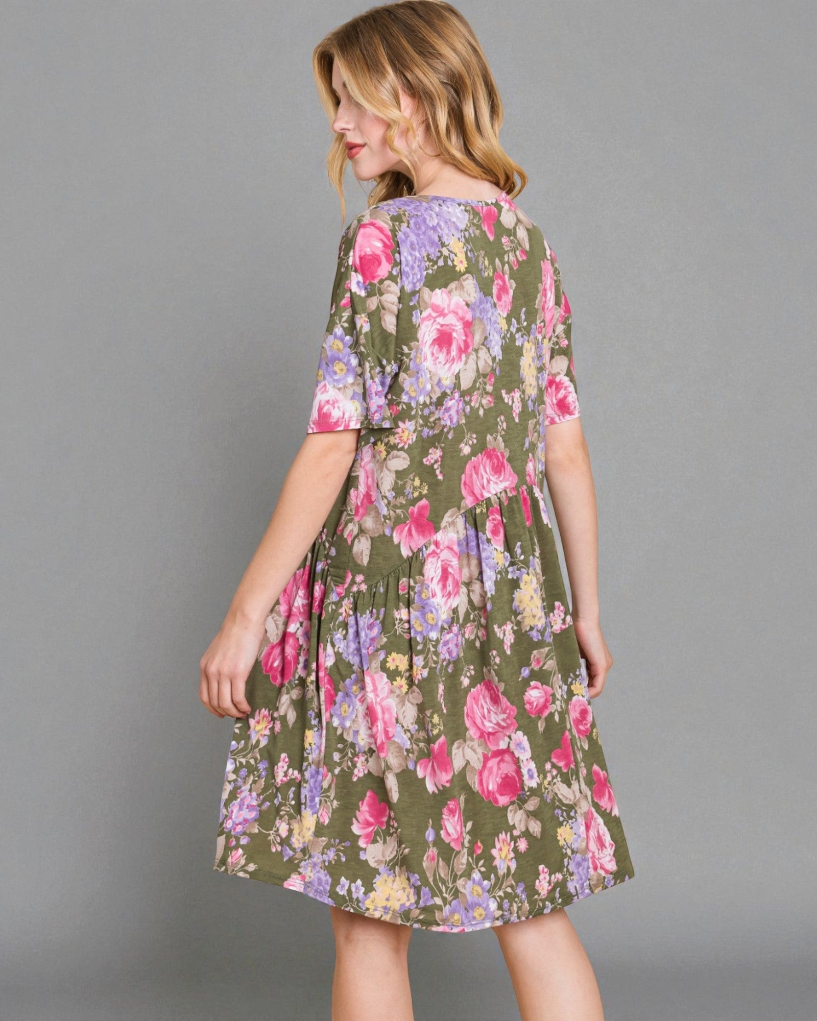 Woman wearing a floral dress on a gray background