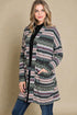Woman wearing a patterned cardigan against a beige background
