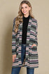 Woman wearing a patterned cardigan against a beige background