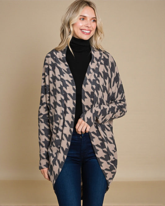 Woman wearing a houndstooth patterned coat against a beige background