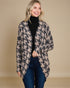 Woman wearing a houndstooth patterned coat against a beige background