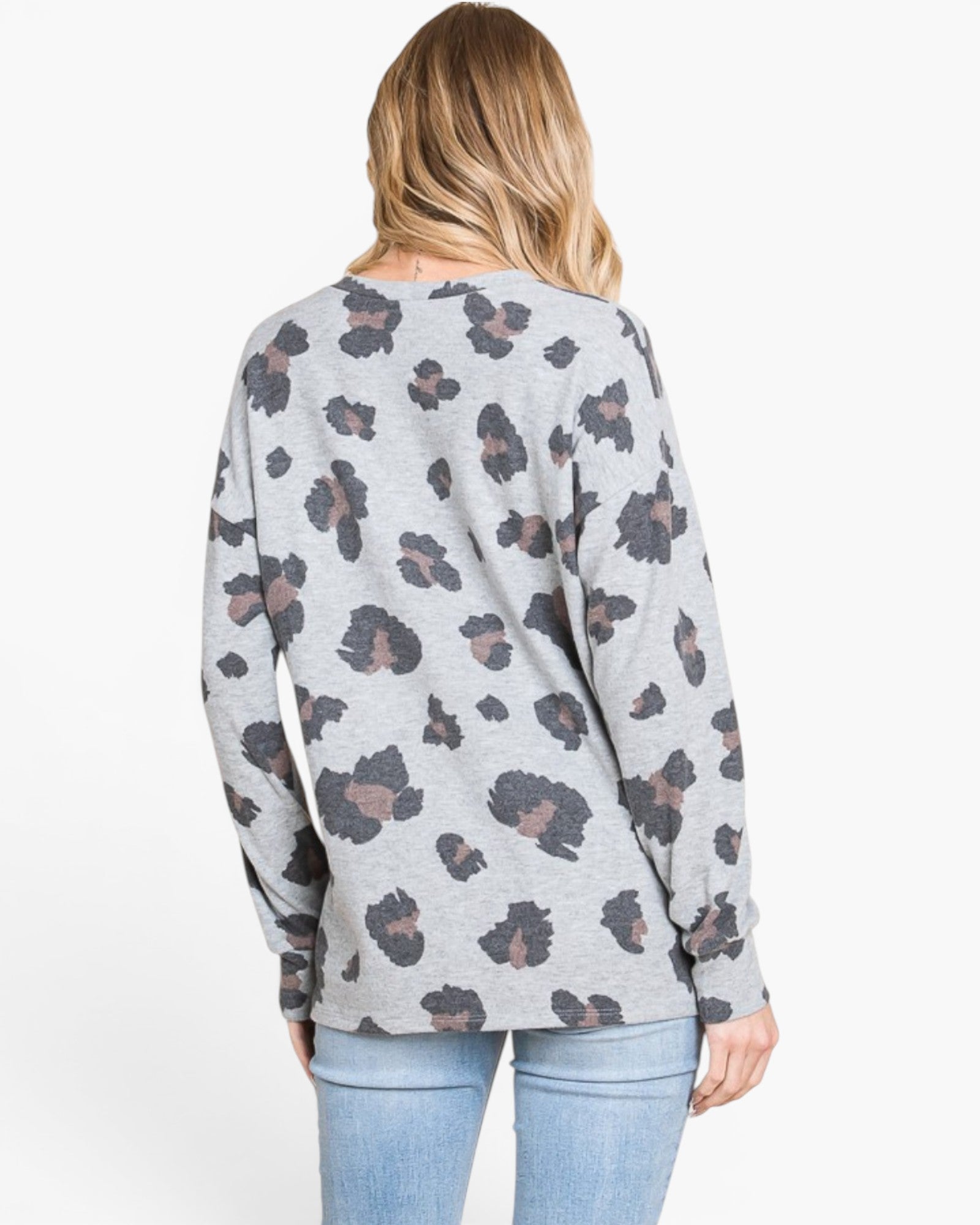 A woman shown from the back wearing a light gray long-sleeve top with a dark gray and brown leopard print, paired with light blue jeans, against a plain white background.