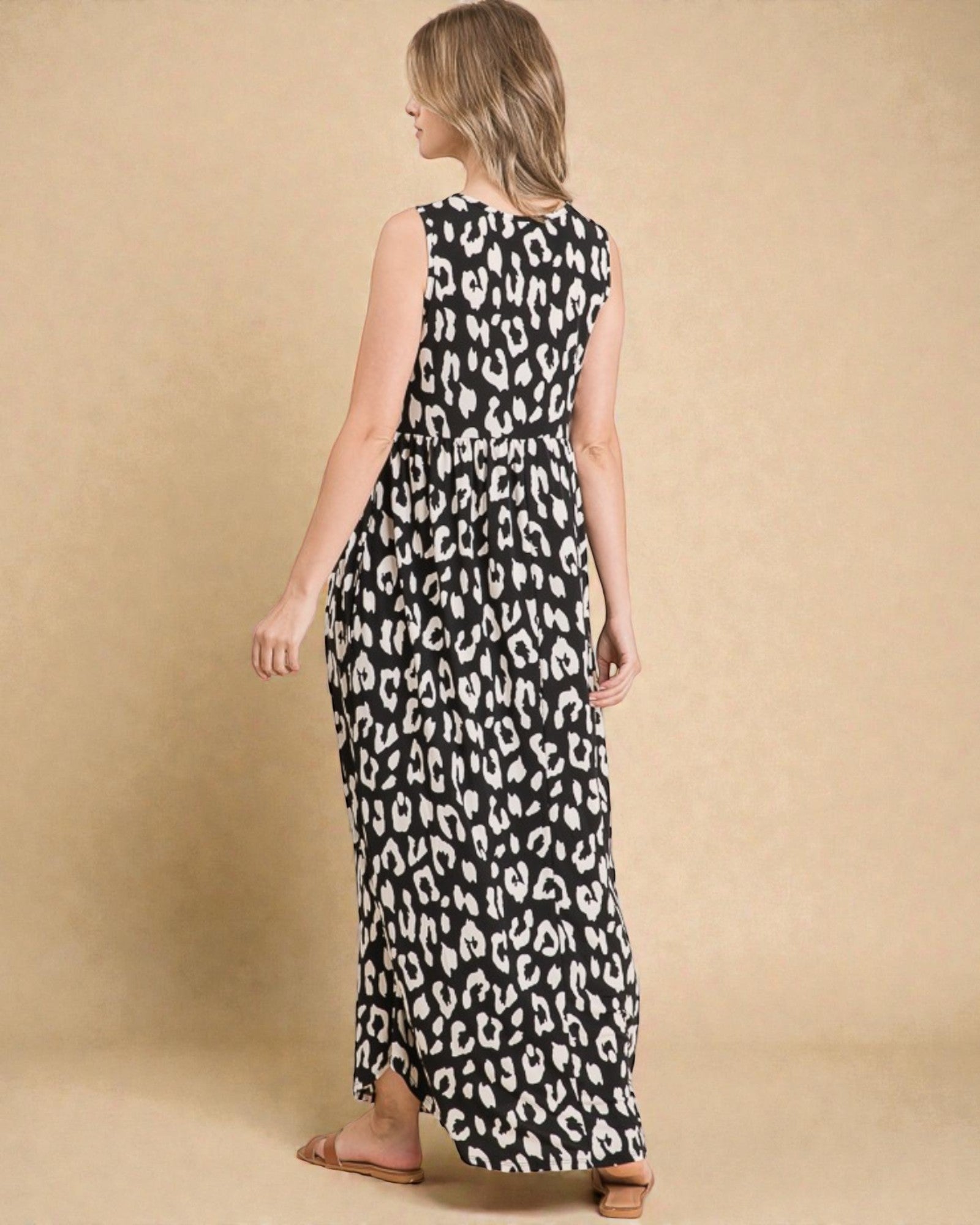 Woman wearing a black and white leopard print dress against a beige background