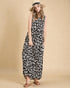Woman wearing a black and white leopard print dress with a beige background