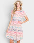 Woman wearing a colorful dress with a pattern on a plain background