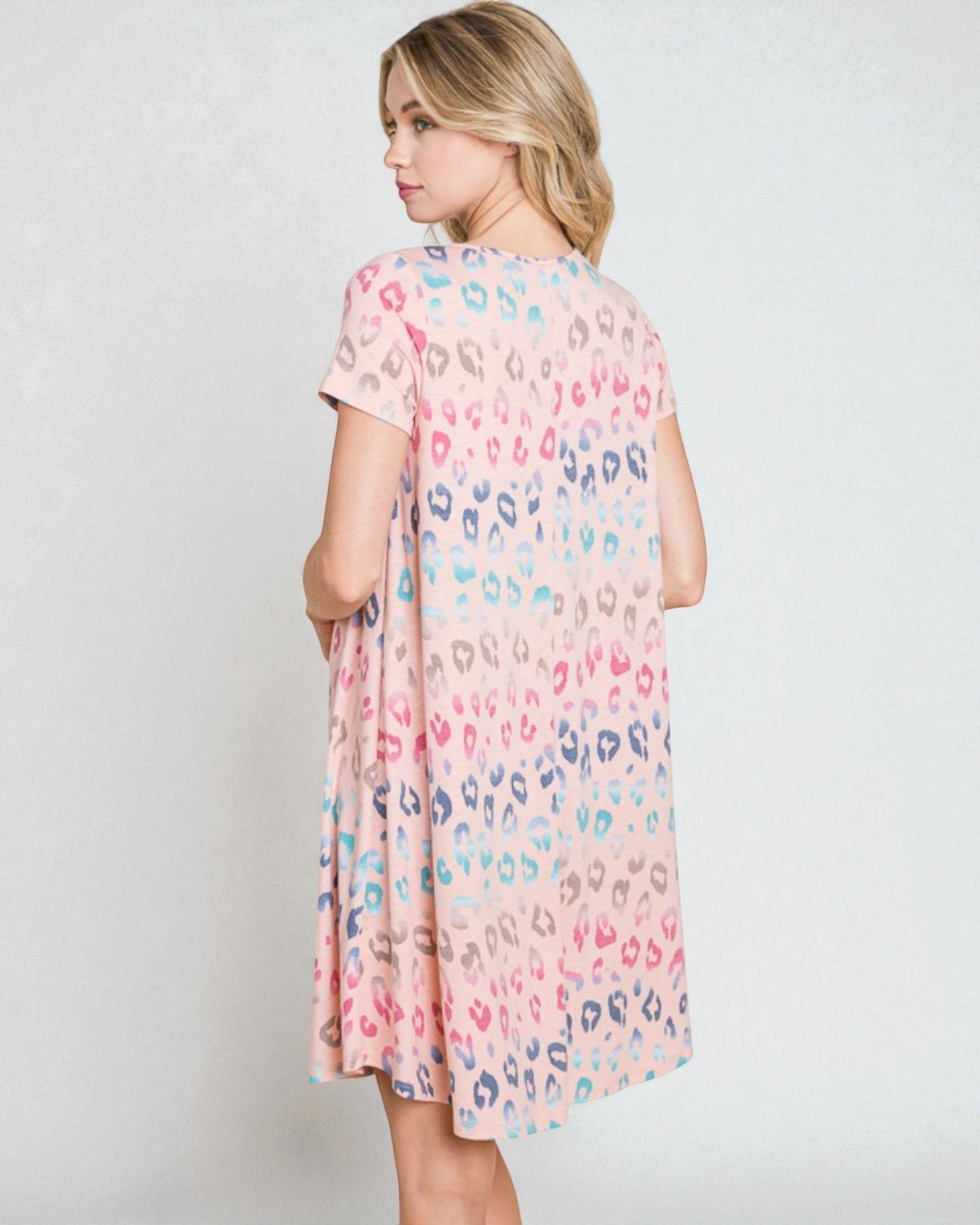 Woman wearing a pastel leopard print dress against a white background