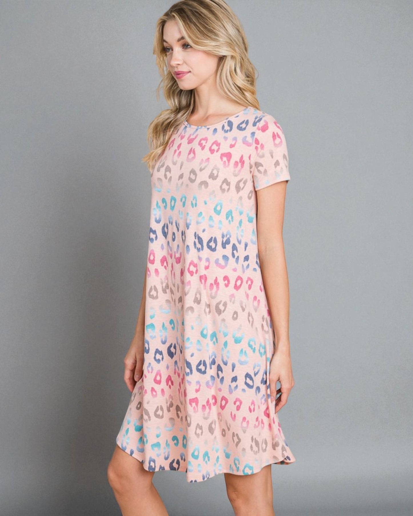 Woman wearing a pastel leopard print dress against a gray background