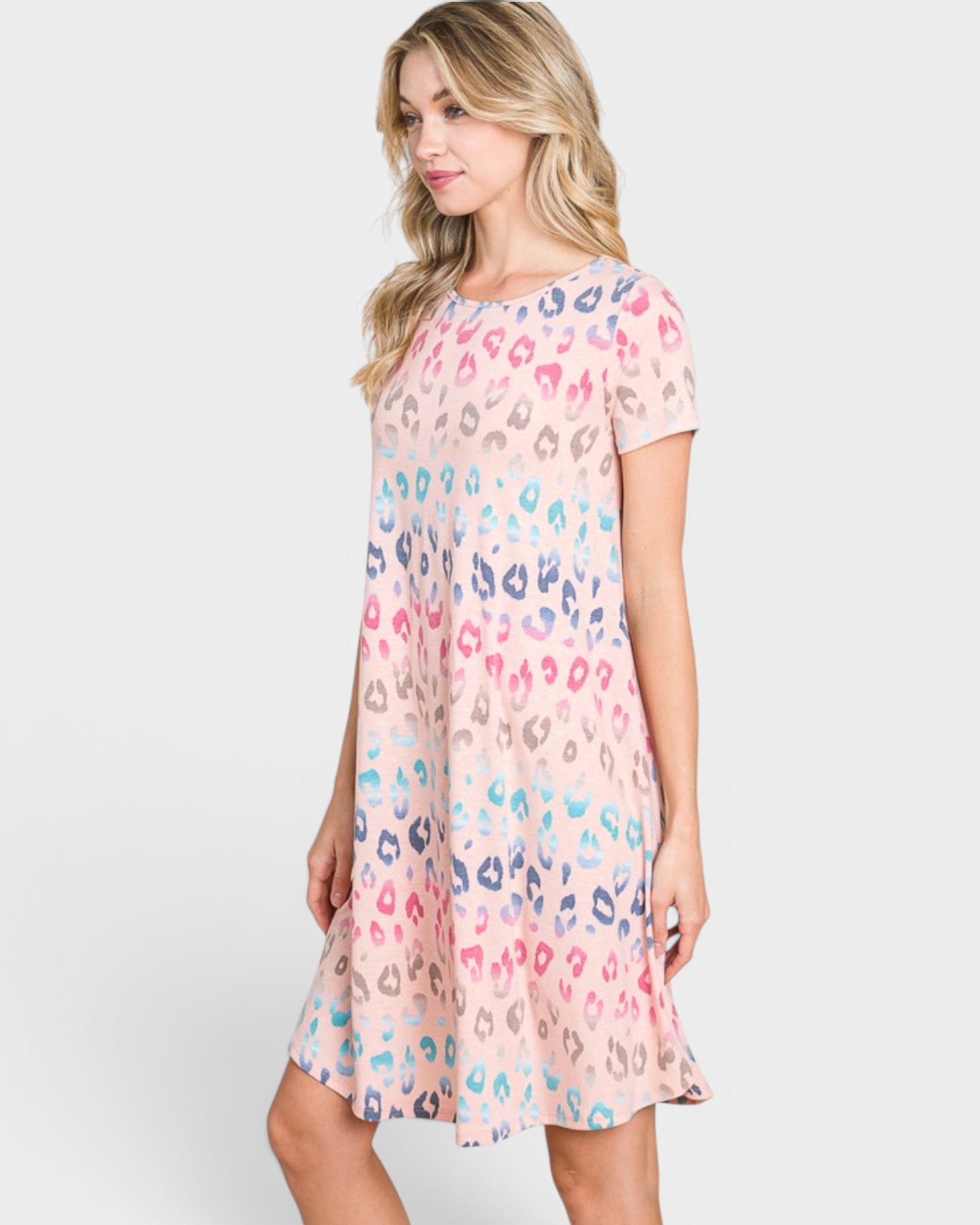 Woman wearing a pastel leopard print dress on a white background
