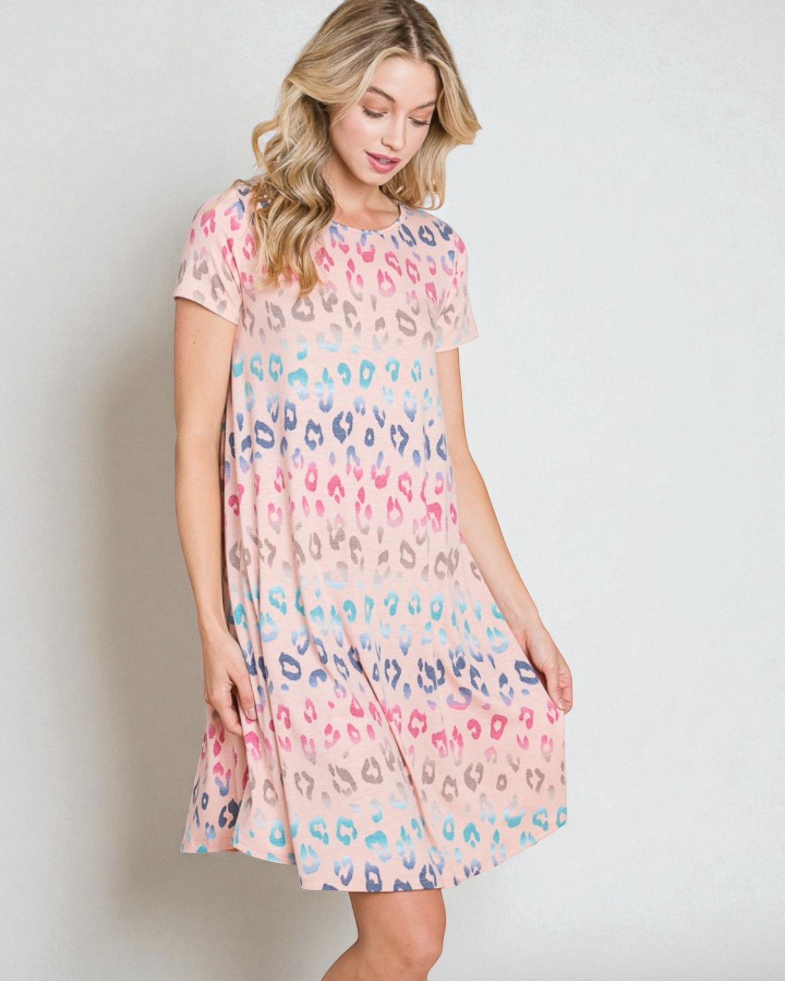 Woman wearing a colorful dress with a pattern on a plain background