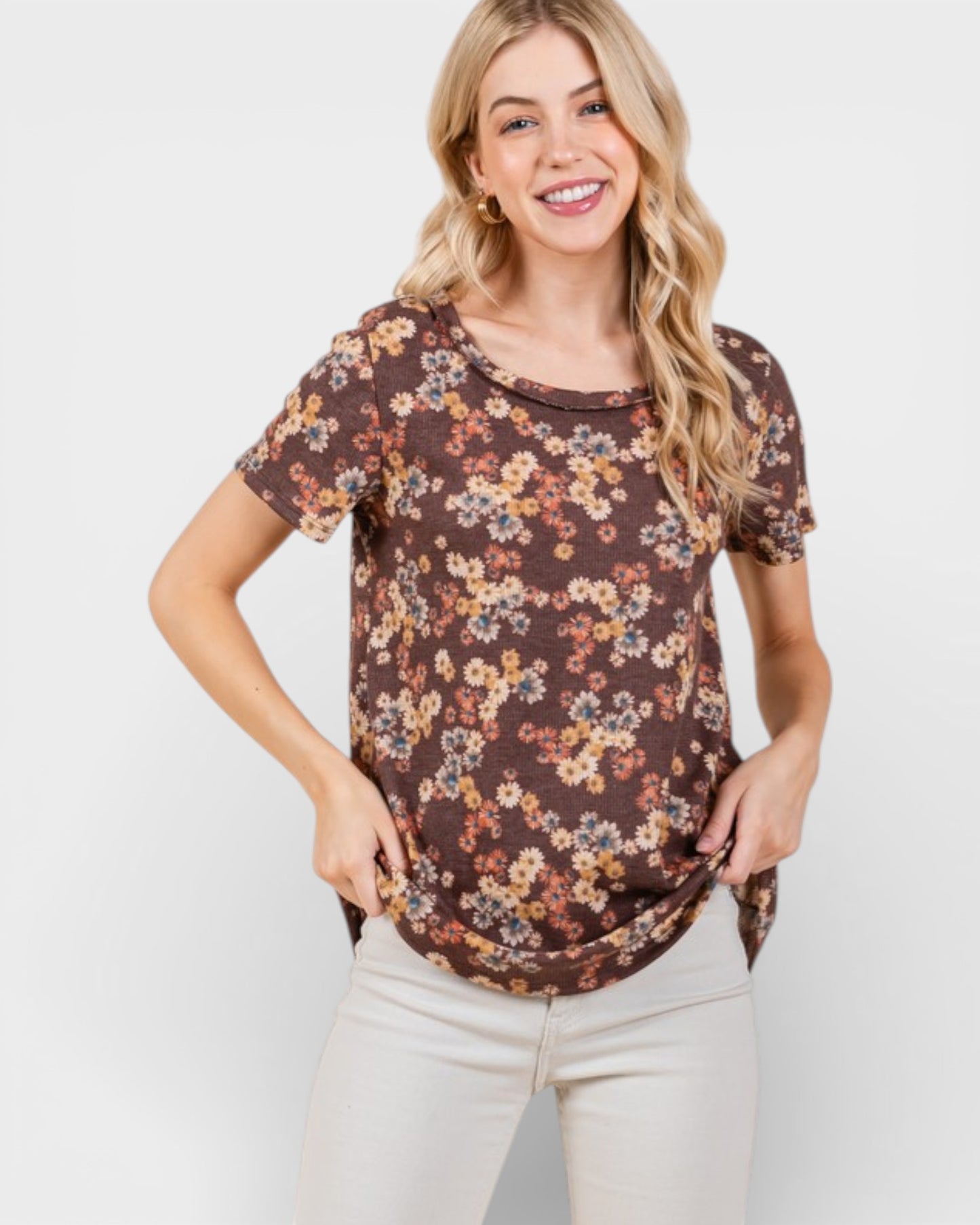 Woman wearing a brown floral top against a white background