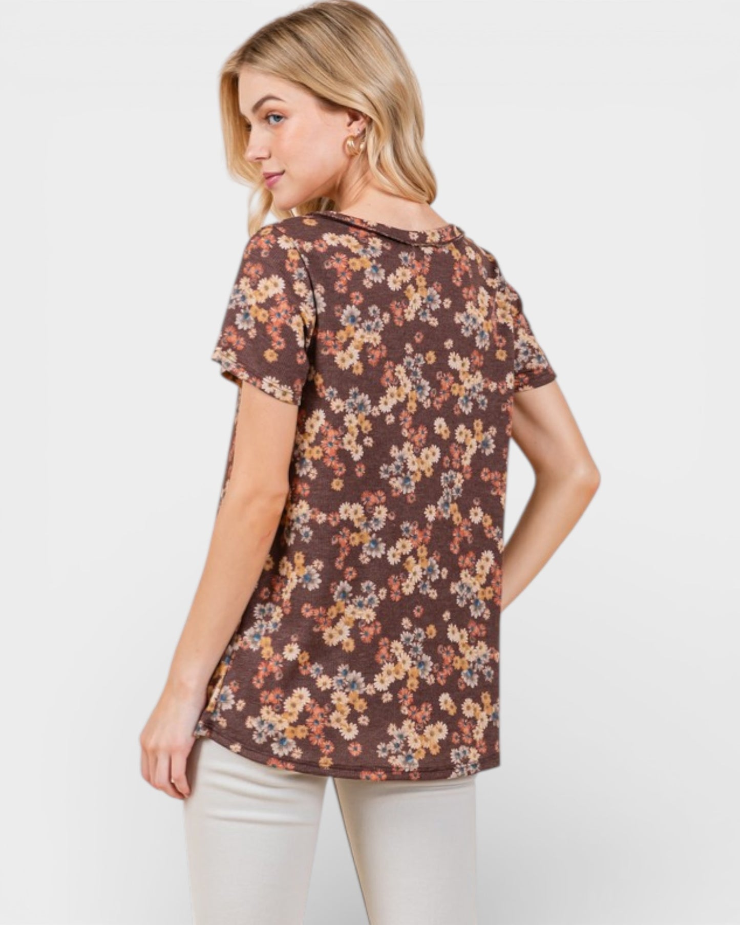 Woman wearing a brown floral-patterned shirt on a white background