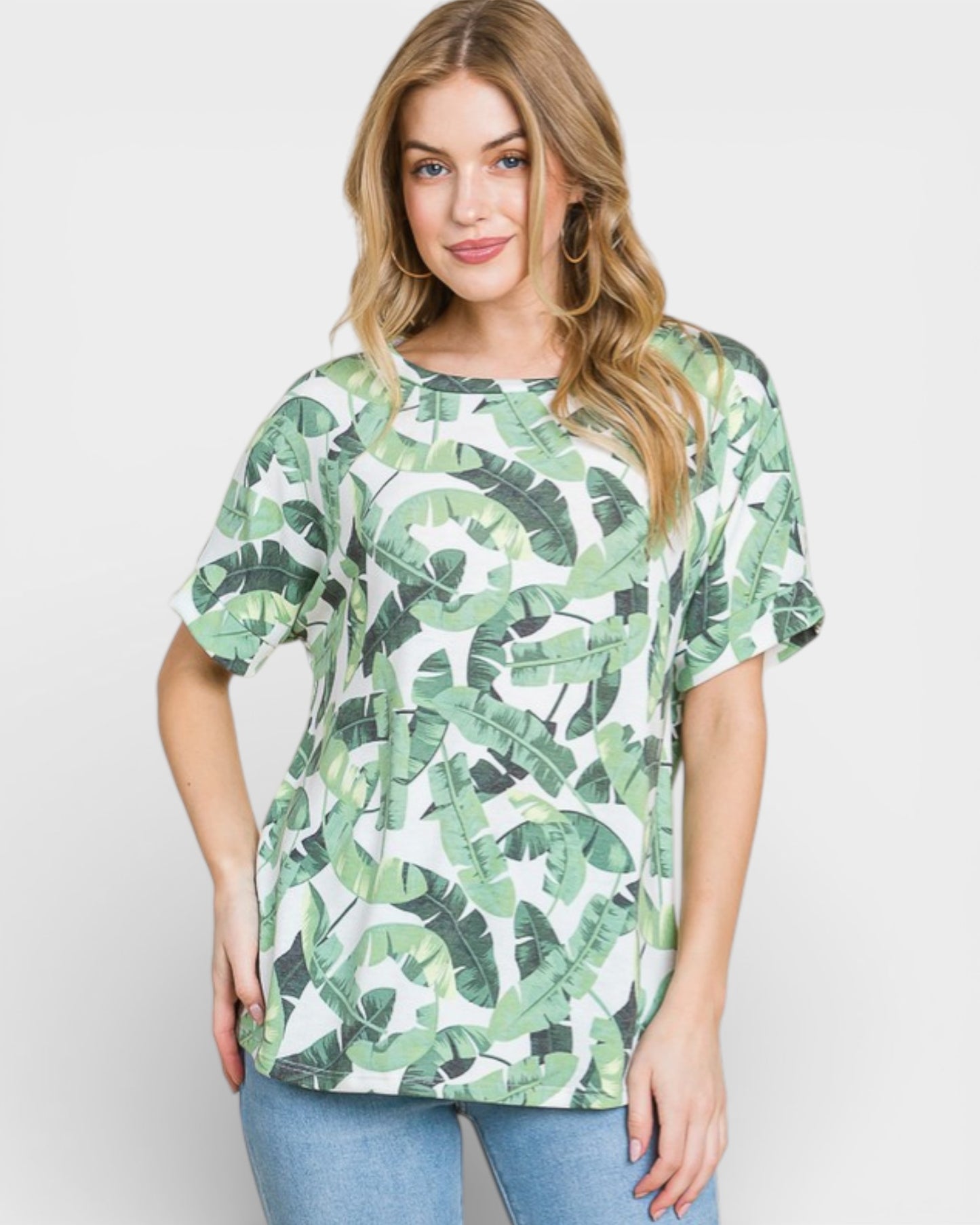 Woman wearing a green leaf patterned shirt on a white background