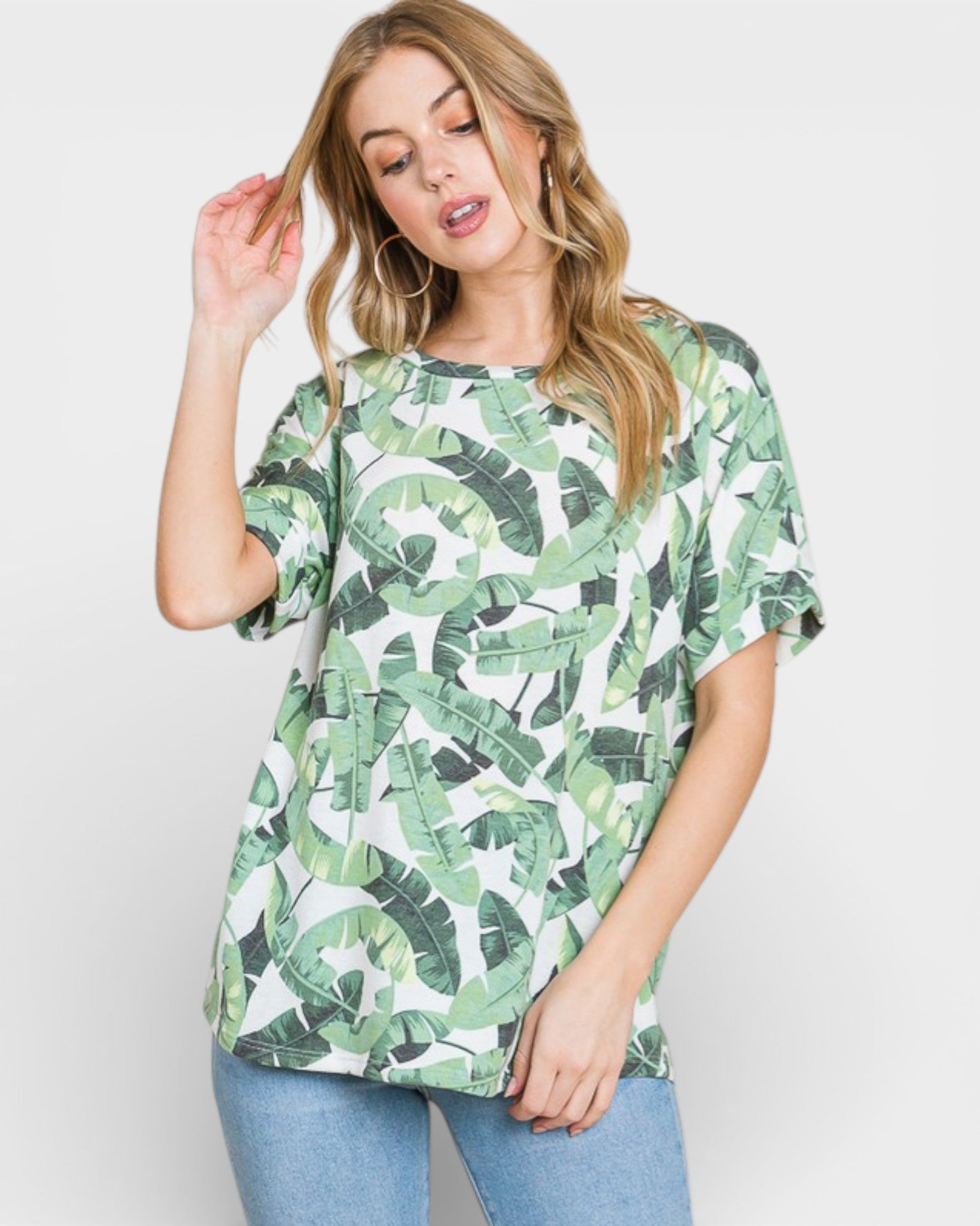 Woman wearing a green leaf patterned shirt on a white background