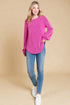 Woman wearing a pink sweater and blue jeans on a beige background