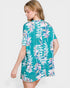 Woman wearing a teal floral dress on a white background