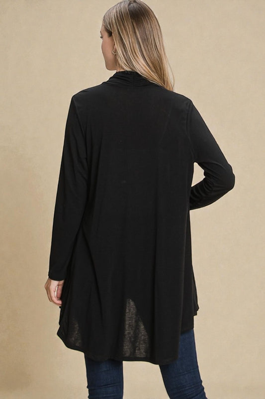 Woman wearing a black cardigan on a beige background