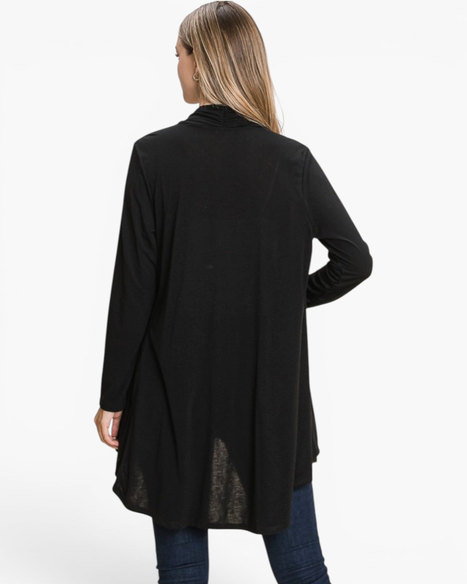A woman shown from the back wearing a black long-sleeve tunic-style top with a high-low hem and sheer lace inset at the bottom, paired with blue jeans against a plain white studio background.