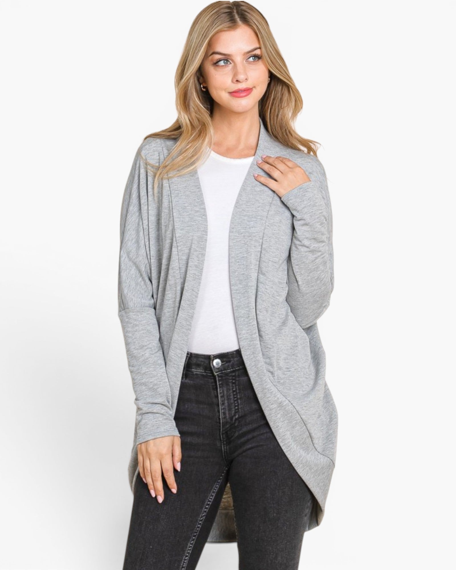 A woman modeling a light gray open-front cardigan over a white top and black jeans, photographed against a plain light gray studio background.
