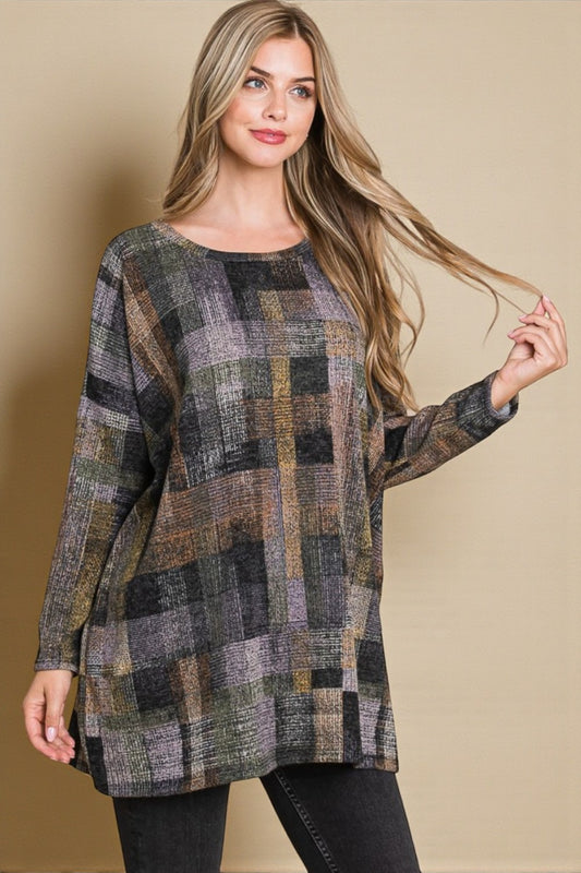 Woman wearing a plaid patterned sweater against a beige background