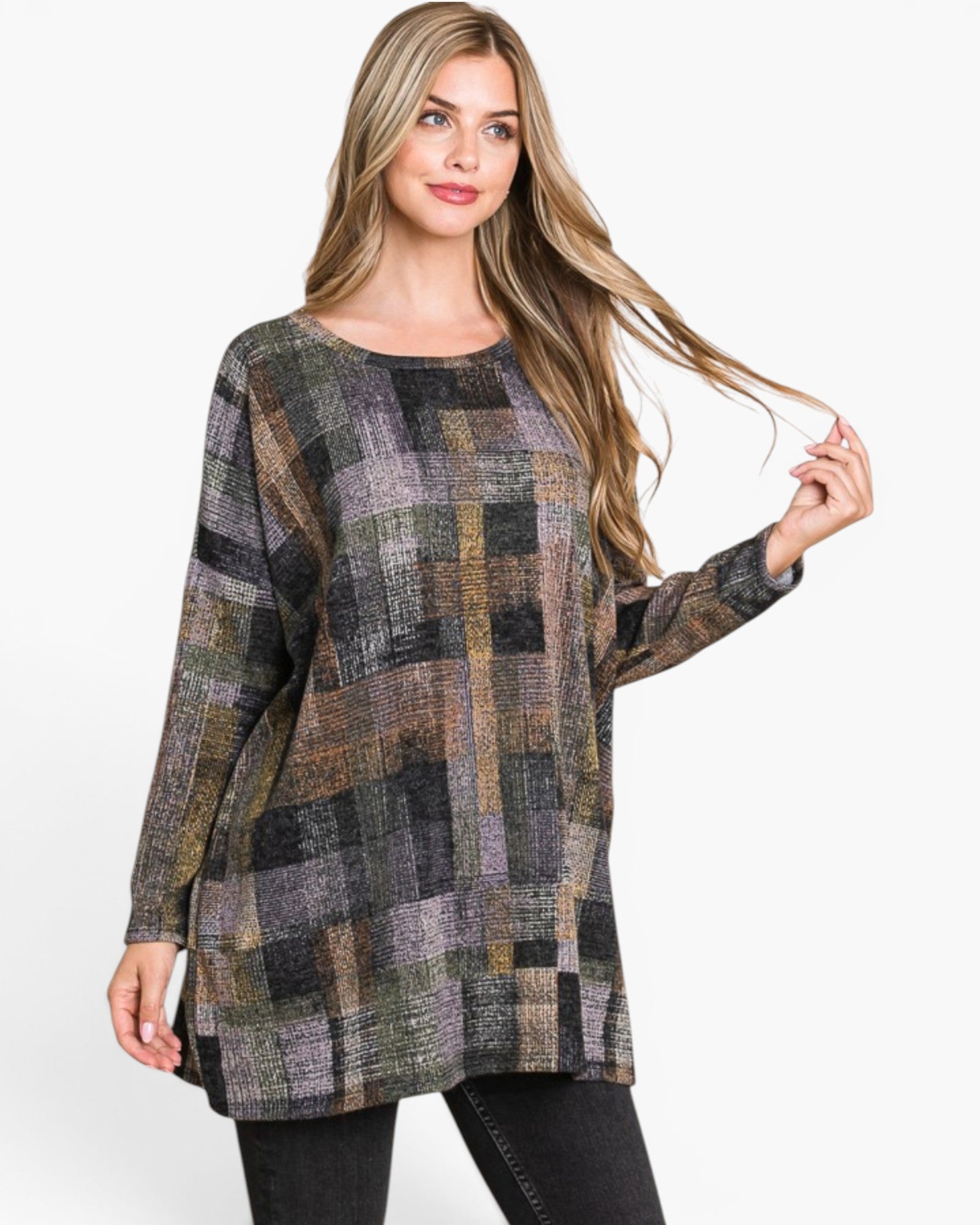 A woman modeling a long-sleeve, boat-neck tunic top with a textured patchwork plaid pattern in muted shades of gray, brown, olive green, and beige, paired with black pants against a plain white background.
